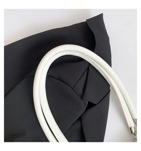 Détail de la poignée en similicuir blanc rembourré et des coutures du sac à bandoulière