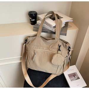 Detail of khaki nylon tote bag featuring front zip pocket and detachable round coin purse