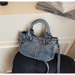 Dettaglio ravvicinato della borsa tote in denim lavato azzurro con rivetti in metallo