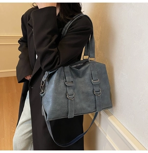 Side view of a vintage large blue-grey tote bag in matte faux leather with silver buckles