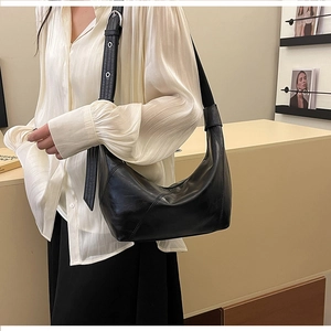 Detail of adjustable leather shoulder strap with silver buckle on black hobo bag