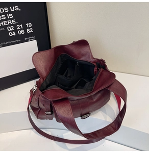 Detailed view of the burgundy tote bag interior with multiple pockets and black lining