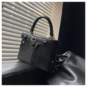 Detail view of vintage black box bag with lychee texture and gold metal buckle hardware