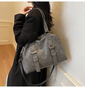 Gray large-capacity tote bag with silver metal ring detail shown on a model