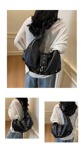 Detailed view of large black tote bag featuring silver star studs and litchi texture
