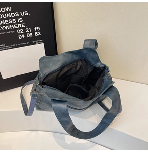 Detail view of large dark blue tote bag showing interior compartments and fabric strap