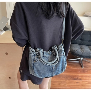Dettaglio della borsa tote in denim lavato con tasche e zip su un outfit casual
