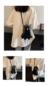 Vue détaillée du sac bandoulière fantôme noir en cuir PU mat avec des patchs d'yeux blancs