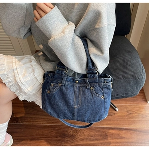 Vista dall'alto di una borsa tote in denim vintage con tasche decorative e rivetti in metallo