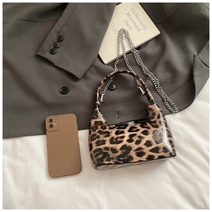 Close-up of leopard print patent leather bag with silver chain and crescent shape