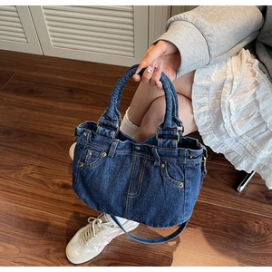 Dettaglio della borsa tote in denim lavato vintage con design in vita e cuciture