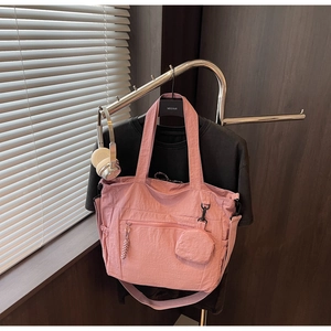 Detailed shot of pink nylon tote bag with small round pouch and detachable shoulder strap