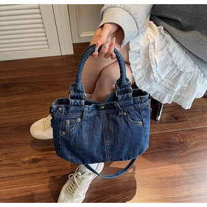 Vista dettagliata della borsa tote in denim blu scuro con tasca vintage e rivetti in metallo