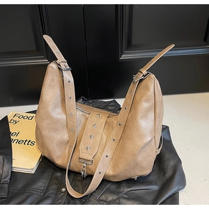 Detail of khaki leather tote with adjustable strap and star rivet hardware decoration