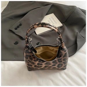 Detail view of leopard print handbag showing golden lining and secure zipper closure