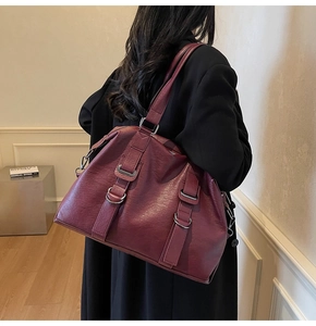 Detail of dark red-brown tote bag featuring lychee texture leather and silver hardware