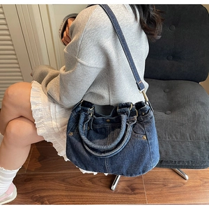 Dettaglio della borsa tote in denim blu lavato con rivetti metallici e design vintage