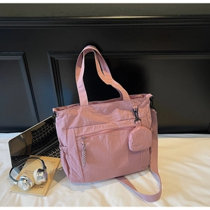 Pink nylon tote bag detail with drawstring side pocket and round coin purse attachment