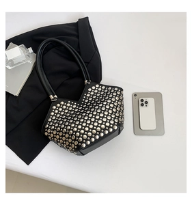 Détail du sac bandoulière noir avec rivets métalliques et ouverture unique en V