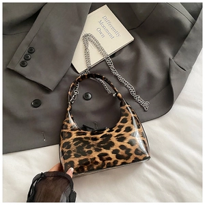 Detailed view of glossy leopard print handbag with silver chain strap and smooth texture