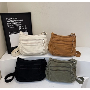 Multi-pocket canvas shoulder bag detail showing four colors and wide shoulder straps