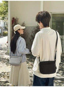 Détail de sacs bandoulière minimalistes en nylon noir et gris avec des sangles réglables