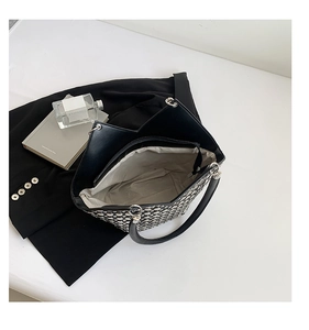 Détail du sac à bandoulière noir à rivets avec ouverture en V et poche zippée interne