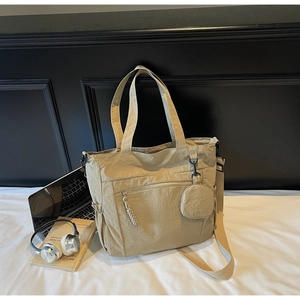 Close-up of beige nylon tote bag with front zipper pocket and round coin pouch