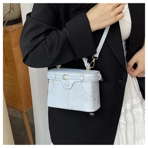 Close-up of vintage denim-style mini box bag with metallic hooks and leather shoulder strap