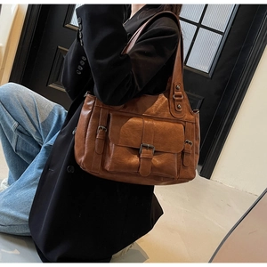 Brown vintage faux leather shoulder bag featuring front flap pocket and metal buckle detail