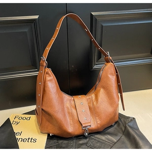 Detail of brown hobo bag with vintage leather texture and silver star rivet hardware