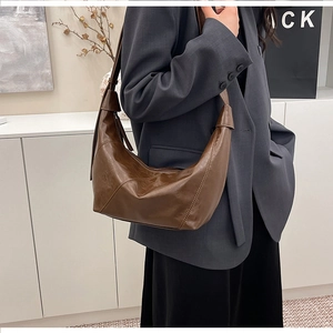 Detail view of a vintage dark brown hobo bag with pleated texture and stylish shoulder strap