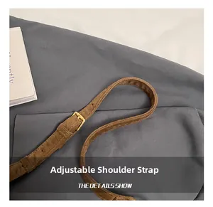 Detail of adjustable suede shoulder strap with golden metal buckle for crossbody bag