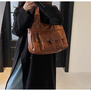 Detailed view of caramel brown large capacity crossbody bag with front buckled pockets