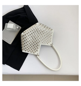 Détail du sac à bandoulière blanc style punk avec clous argentés sur surface en cuir