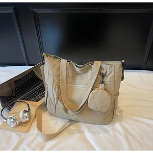 Detail view of khaki nylon tote bag with small round coin purse and adjustable strap