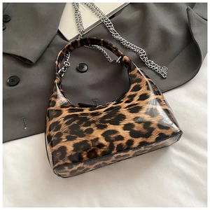 Macro shot of glossy leopard print hobo bag with polished silver metal chain strap