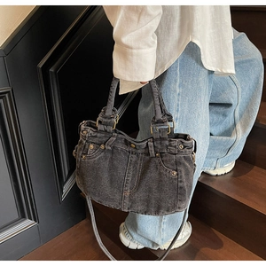 Dettaglio della borsa in denim vintage con rivetti metallici e design con passanti per cintura