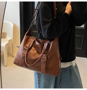 Lifestyle shot of large dark brown leather tote bag worn by a model to show size