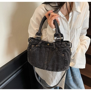 Dettaglio della borsa tote in denim lavato vintage con rivetti metallici e passanti per cintura