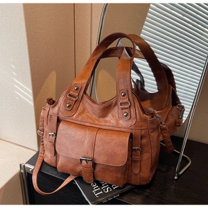 Macro detail of brown pebbled leather texture and vintage hardware on the handbag