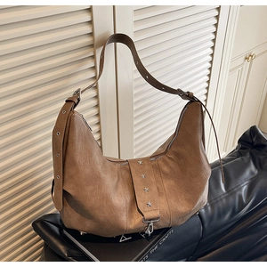 Close-up of vintage brown tote bag with star rivets, silver hardware and leather texture