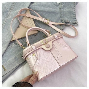 Detail of light pink pearlescent mini denim box bag with golden hardware and belt buckle