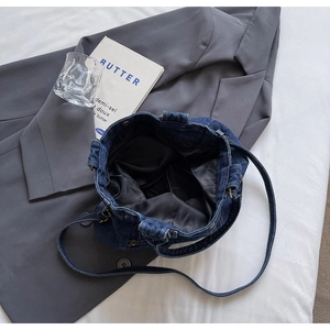 Dettaglio macro della borsa tote in denim vintage con trama e fodera interna grigia