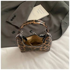 Top-down view of leopard print dumpling bag with metal chain strap and beige lining
