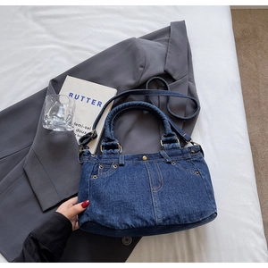Dettaglio della borsa tote in denim blu vintage con tasca ricostruita e rivetti in metallo