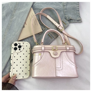 Top view of pink leather handbag with denim style stitching and metal buckle detail