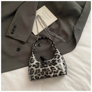 Close-up of leopard print patent leather handbag with silver chain and glossy finish