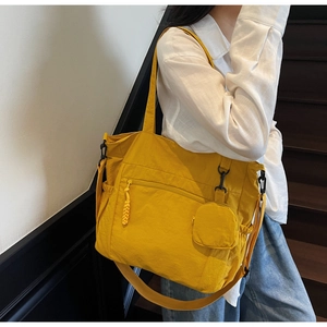Detail of ginger nylon tote bag showing front zipper pocket and round mini coin purse