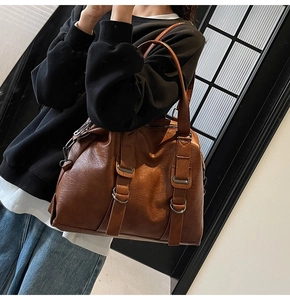 Detail of caramel brown large tote bag with textured faux leather and strap buckle detail